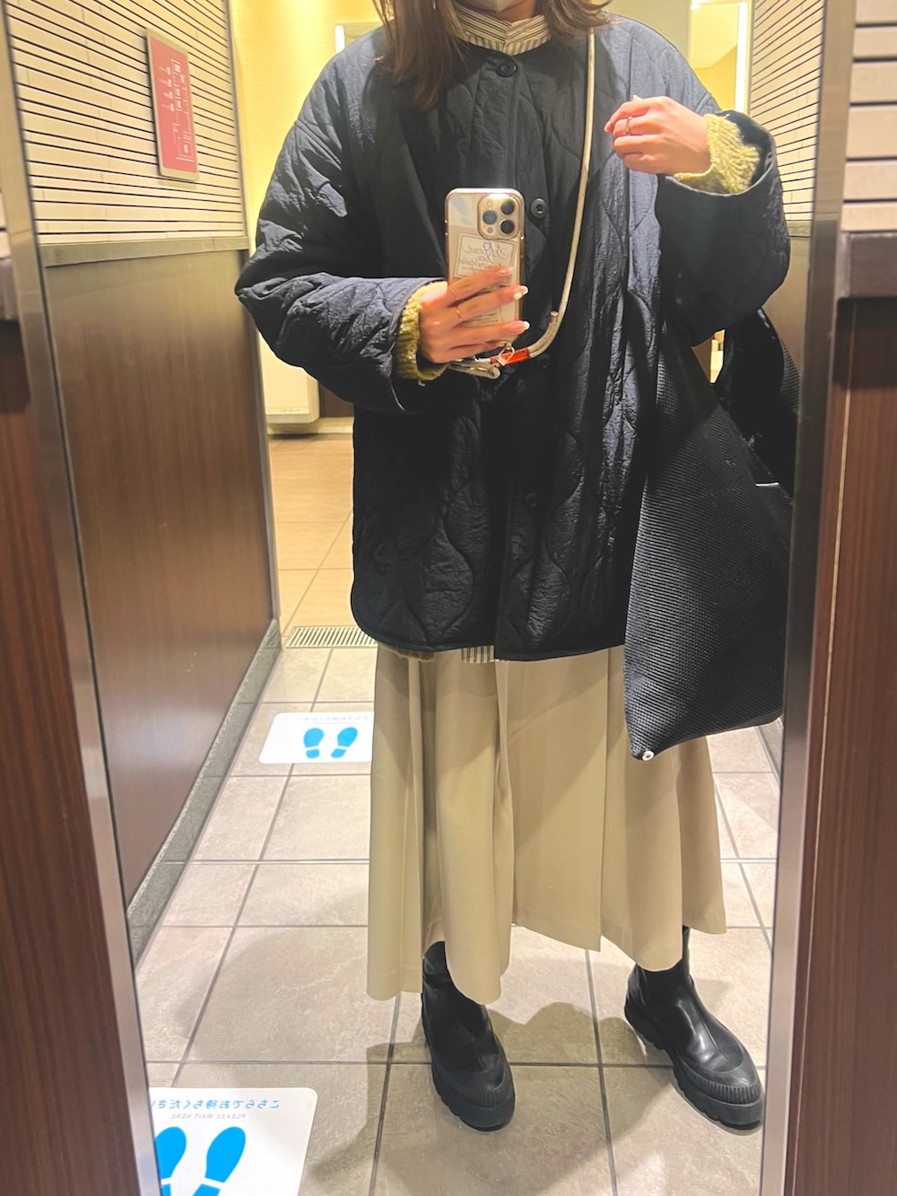 ホワイト系のシャツ/ブラウス、ベージュ系のワンピース、ブラック系のブーツを着用したレディースの冬コーディネートの2枚目の写真