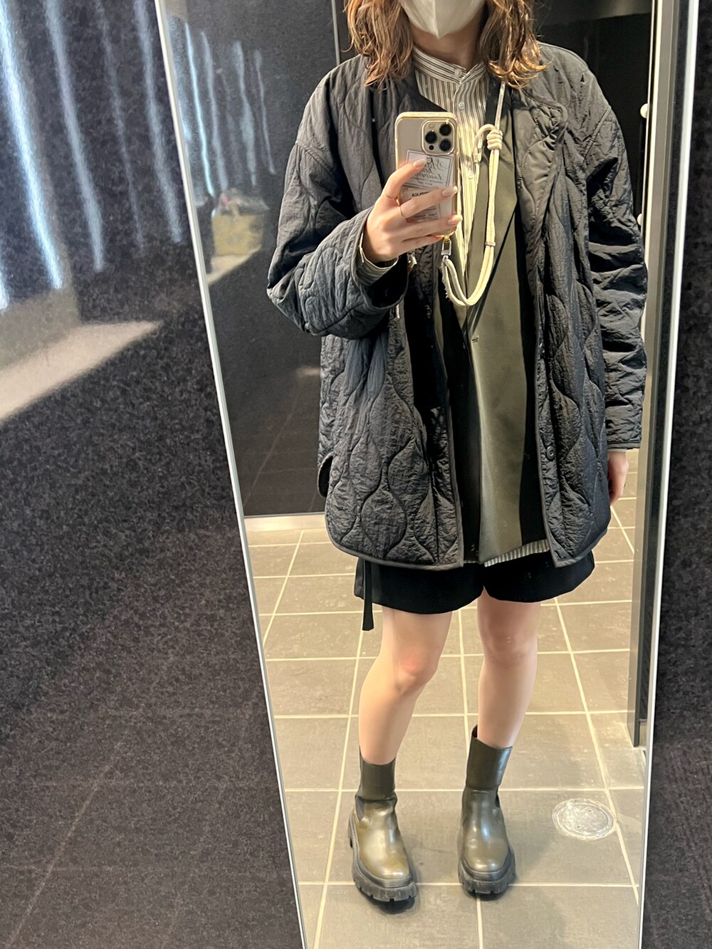 グリーン系のブーツ、ブラック系のその他パンツ、グリーン系のベストを着用したレディースの冬コーディネートの2枚目の写真