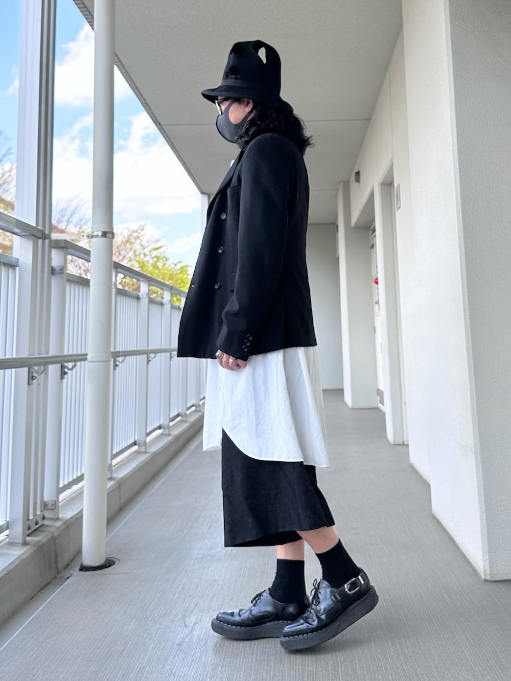 ブラック系のテーラードジャケット、ホワイト系のトップス、ブラック系のパンツを着用したメンズの春コーディネートの2枚目の写真