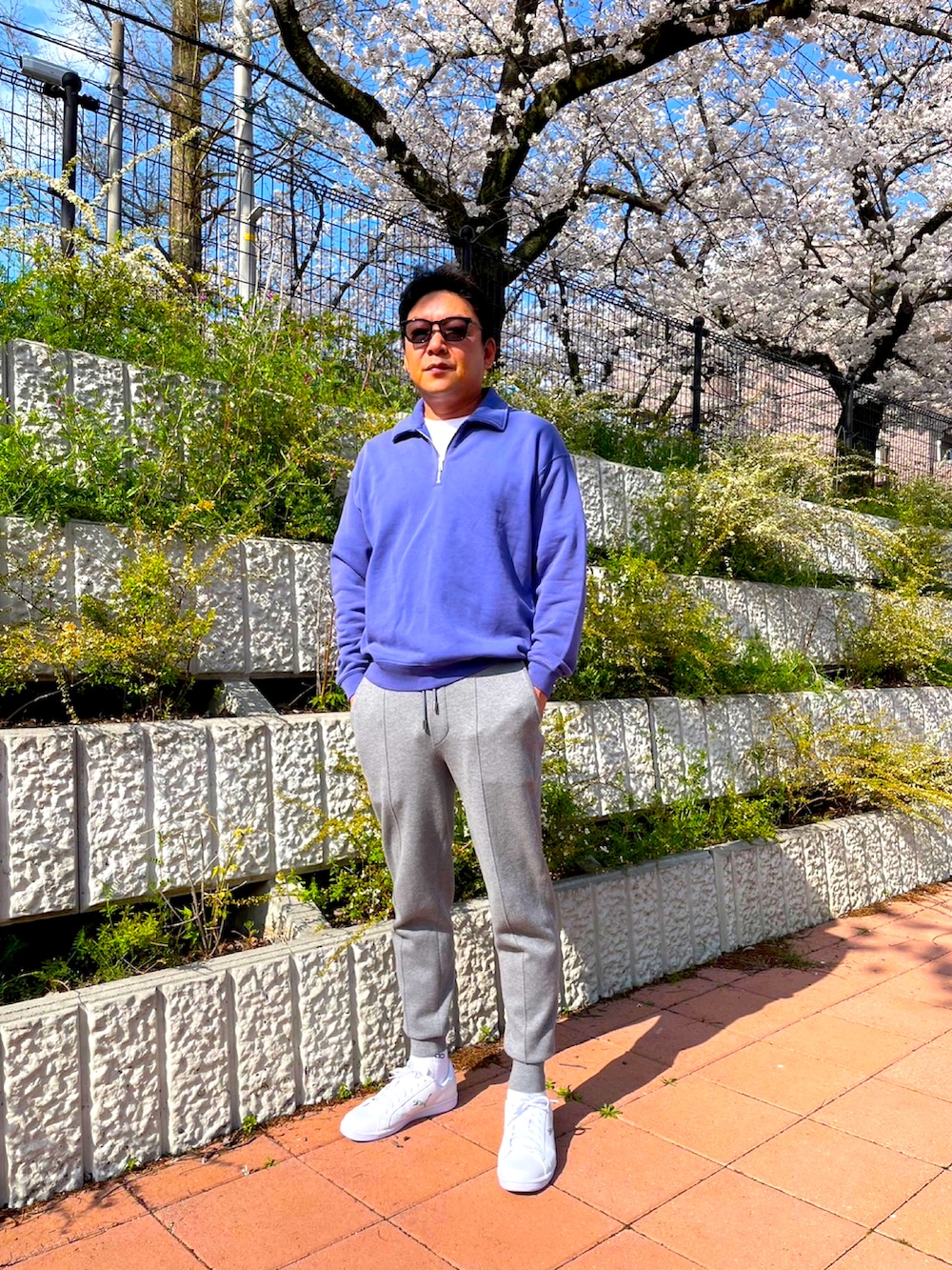 グレー系のその他パンツ、ブルー系のスウェット、ホワイト系のスニーカーを着用したメンズの春コーディネートの2枚目の写真