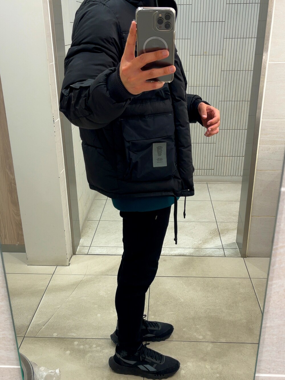 ブラック系のダウンジャケット/コート、グレー系のスウェット、ブラック系のデニムパンツを着用したメンズの冬コーディネートの3枚目の写真