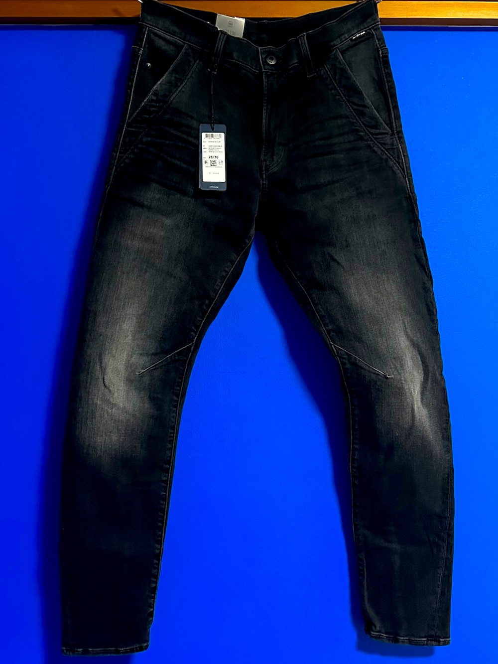 グリーン系のブルゾン、ブラック系のデニムパンツ、ホワイト系のスニーカーを着用したメンズの春コーディネートの3枚目の写真