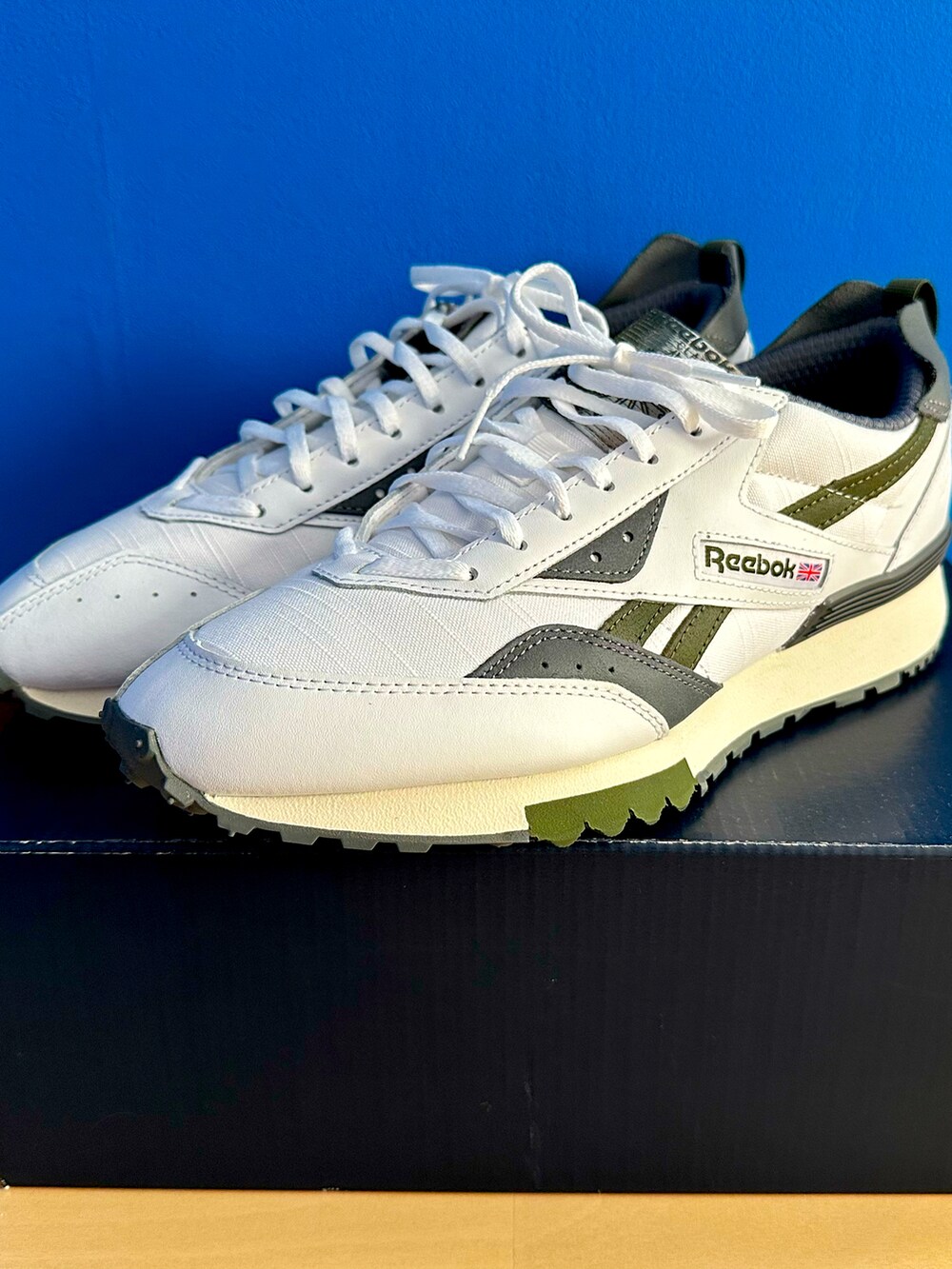 グリーン系のブルゾン、ブラック系のデニムパンツ、ホワイト系のスニーカーを着用したメンズの春コーディネートの4枚目の写真