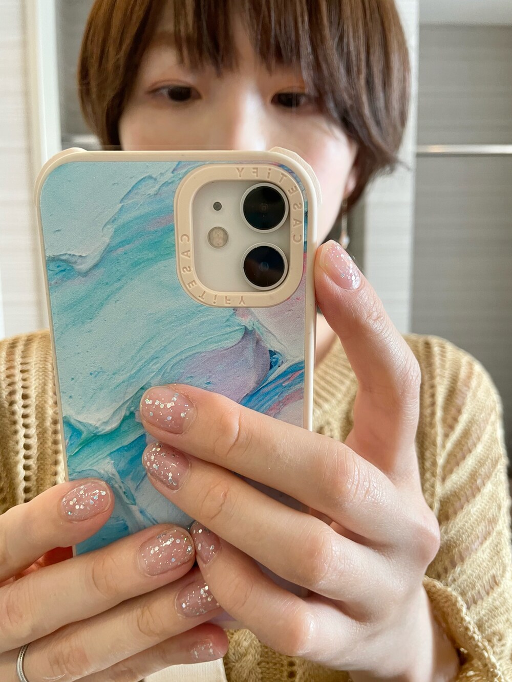 ピンク系のスニーカー、ベージュ系のショルダーバッグ、ゴールド系のニット/セーターを着用したレディースの夏コーディネートの2枚目の写真