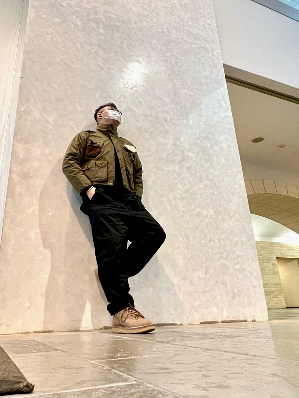 ベージュ系のブーツ、ブラック系のカーゴパンツ、グリーン系のその他アウターを着用したメンズの冬コーディネートの3枚目の写真