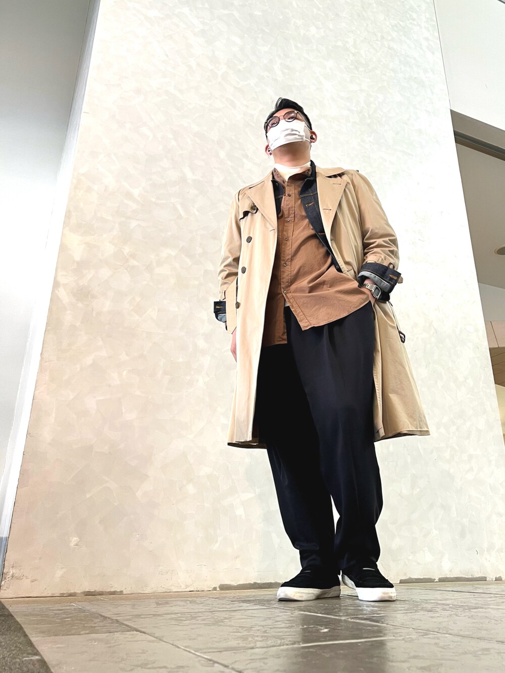 ベージュ系のトレンチコート、ブラック系のスリッポン、ブラック系のその他パンツを着用したメンズの冬コーディネートの2枚目の写真