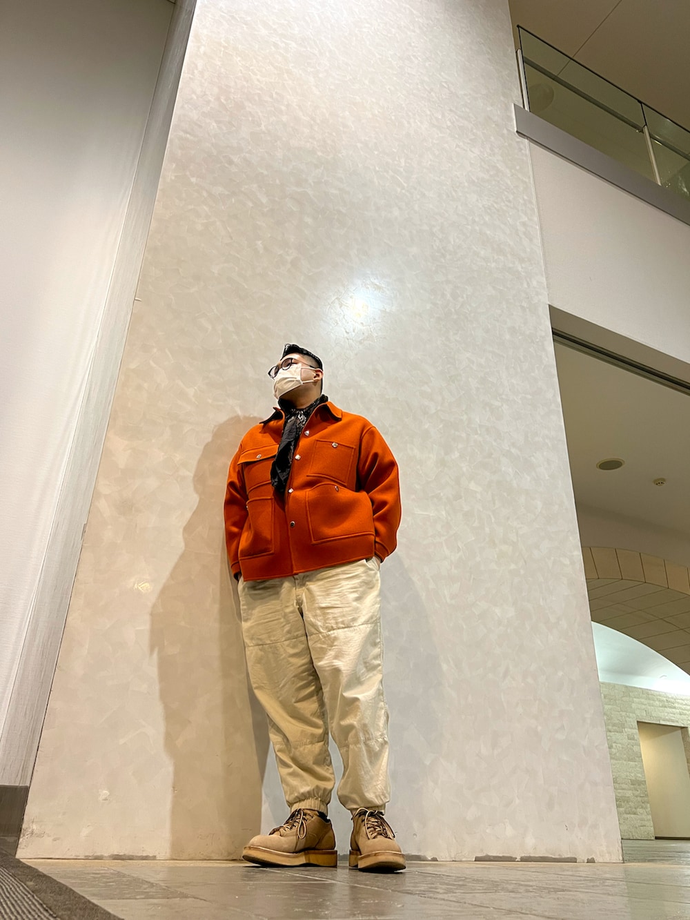 ホワイト系のカーゴパンツ、ベージュ系のブーツ、オレンジ系のカバーオールを着用したメンズの春コーディネートの2枚目の写真