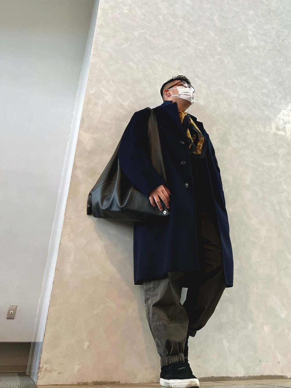 ブルー系のチェスターコート、グリーン系のその他パンツ、ブラック系のスリッポンを着用したメンズの冬コーディネートの2枚目の写真