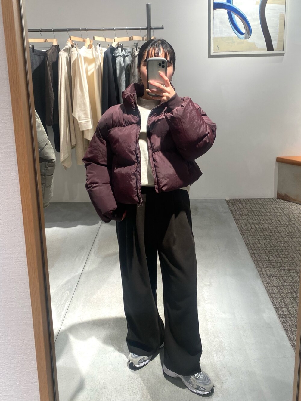 ベージュ系のスウェット、ブラック系のボディバッグ/ウエストポーチ、ブラウン系のダウンジャケット/コートを着用したレディースの秋コーディネートの2枚目の写真