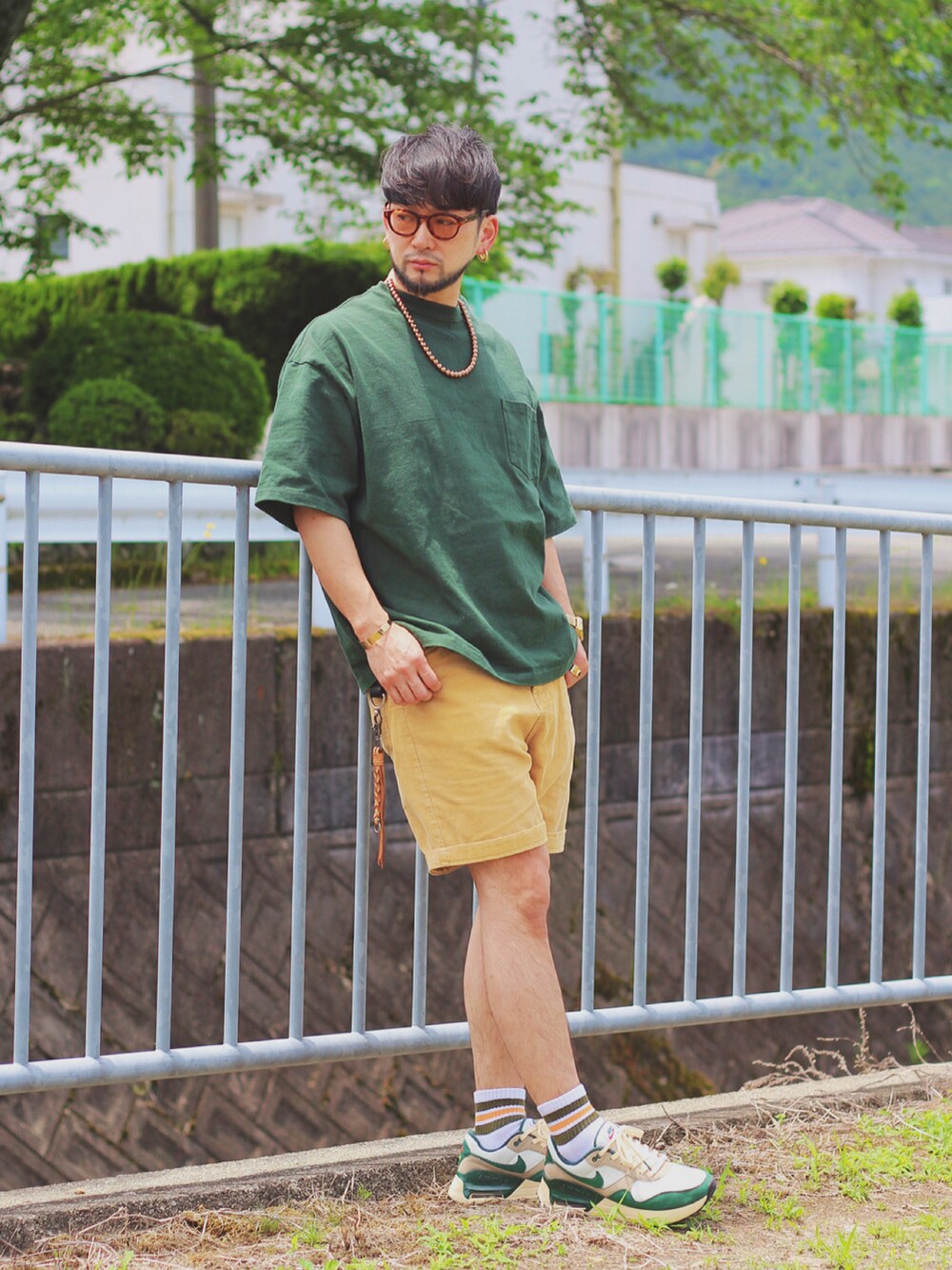 グリーン系のTシャツ/カットソー、グリーン系のスニーカー、ゴールド系の腕時計を着用したメンズの秋コーディネートの2枚目の写真
