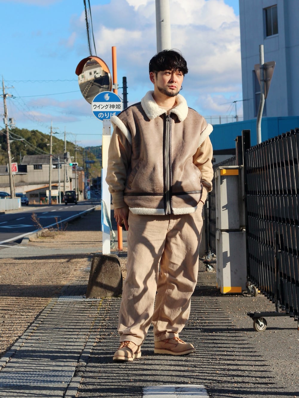 ブラウン系のムートンコート、ベージュ系のブーツを着用したメンズの冬コーディネートの3枚目の写真