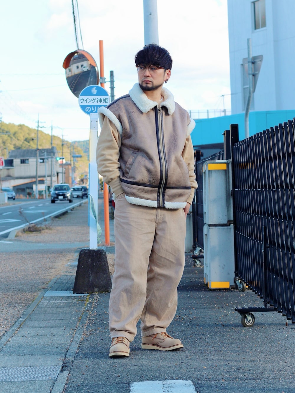 ブラウン系のムートンコート、ベージュ系のブーツを着用したメンズの冬コーディネートの5枚目の写真