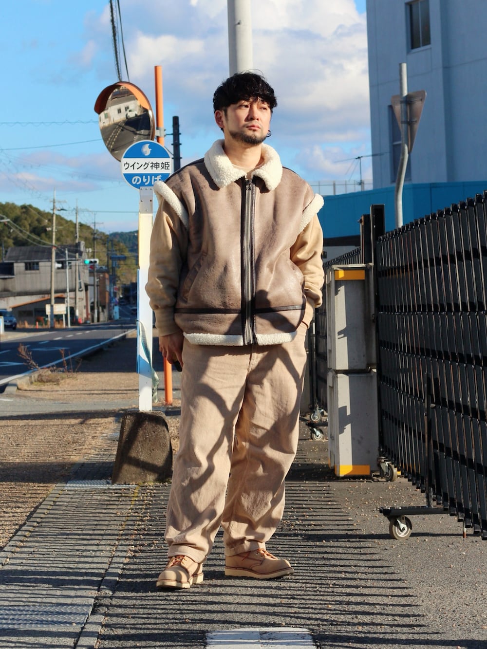 ブラウン系のムートンコート、ベージュ系のブーツを着用したメンズの冬コーディネートの2枚目の写真