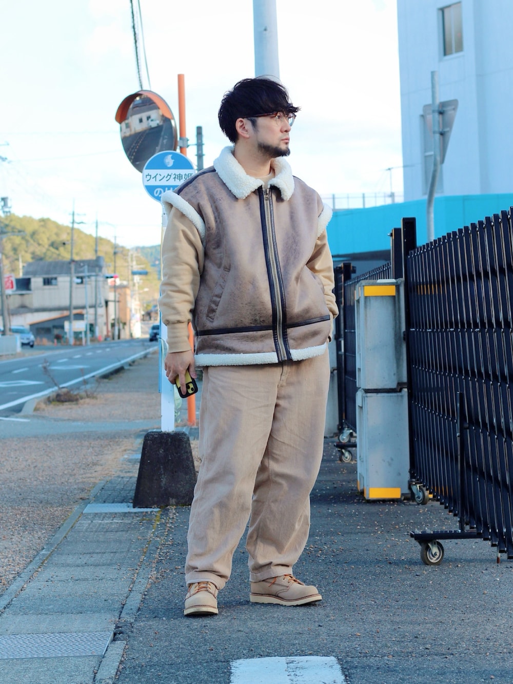 ブラウン系のムートンコート、ベージュ系のブーツを着用したメンズの冬コーディネートの4枚目の写真