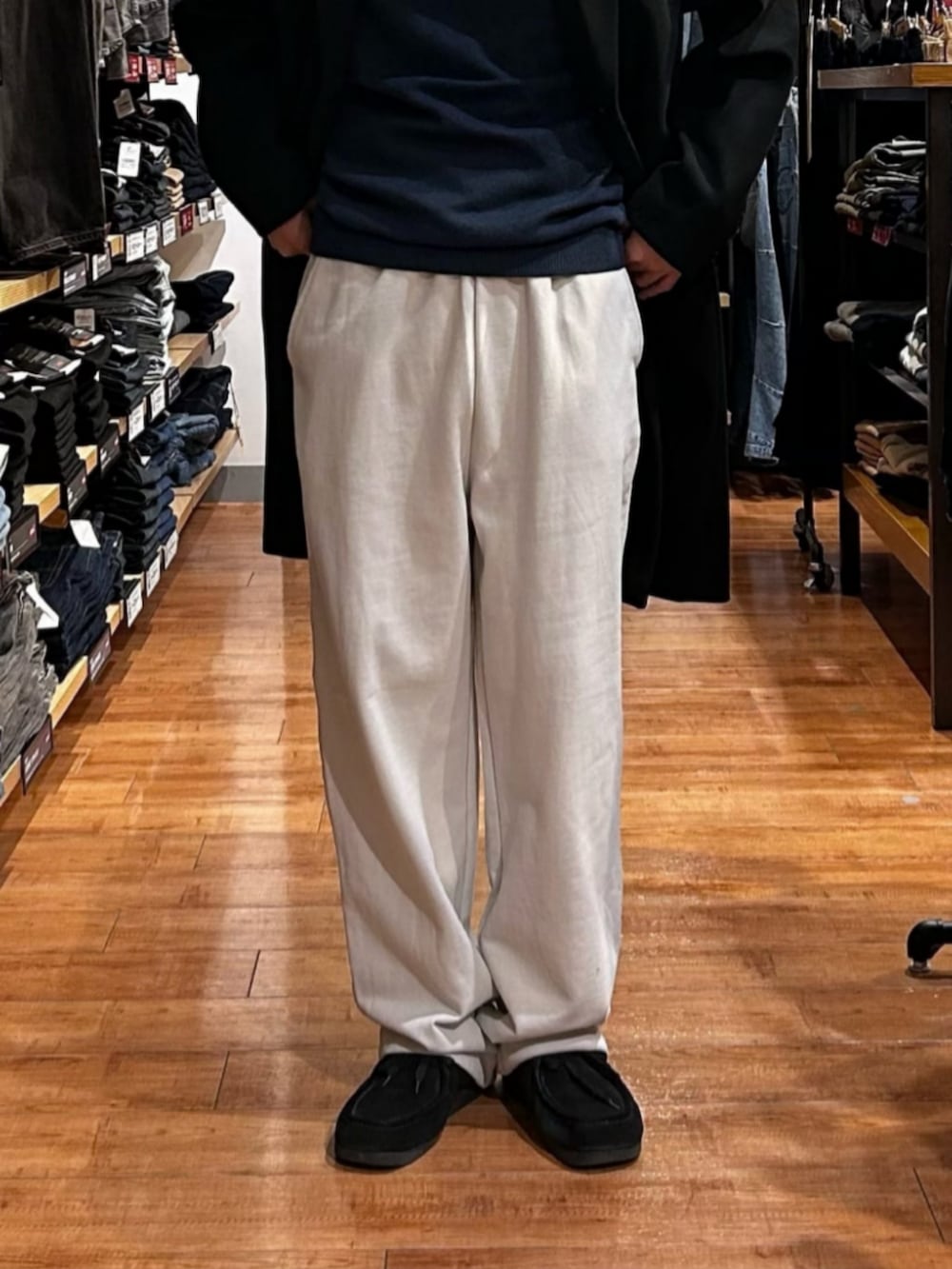 グレー系のその他パンツ、ブルー系のニット/セーター、ブラック系のチェスターコートを着用したメンズの秋コーディネートの8枚目の写真