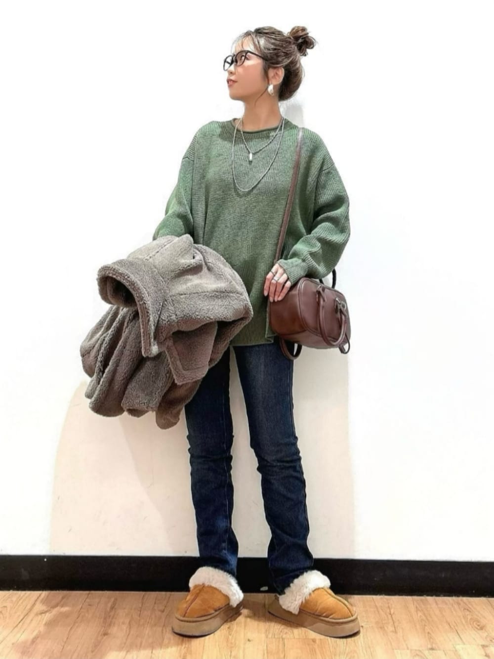 ブラウン系のショルダーバッグ、ブラウン系のその他アウター、グリーン系のニット/セーターを着用したレディースの冬コーディネートの4枚目の写真