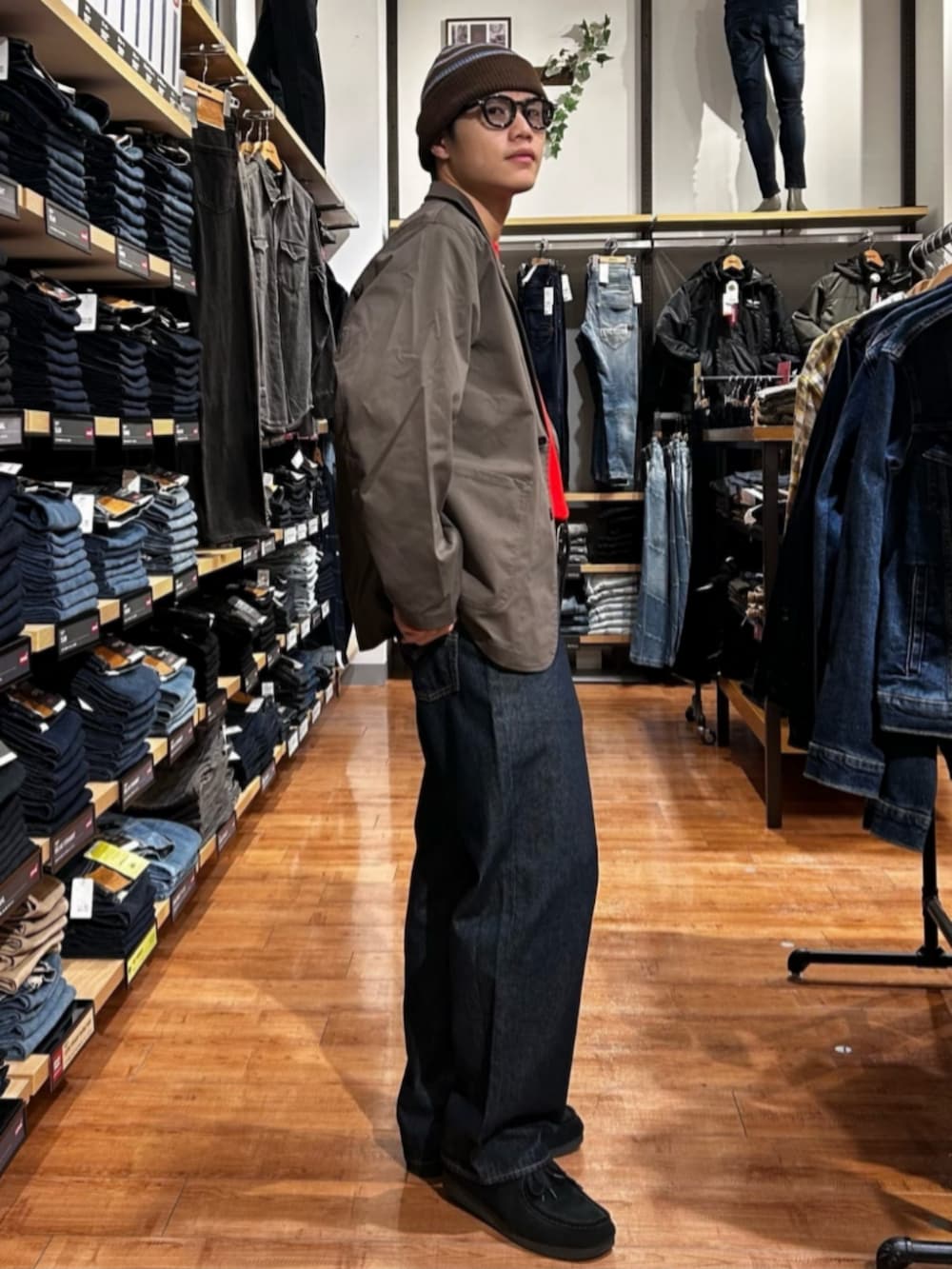 ブルー系のデニムパンツ、レッド系のニット/セーター、ブラウン系のテーラードジャケットを着用したメンズの冬コーディネートの3枚目の写真