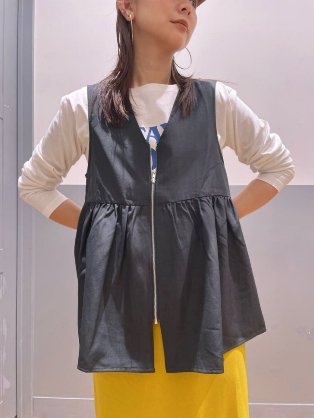 イエロー系のスカート、ホワイト系のTシャツ/カットソー、グレー系のその他トップスを着用したレディースの秋コーディネートの6枚目の写真