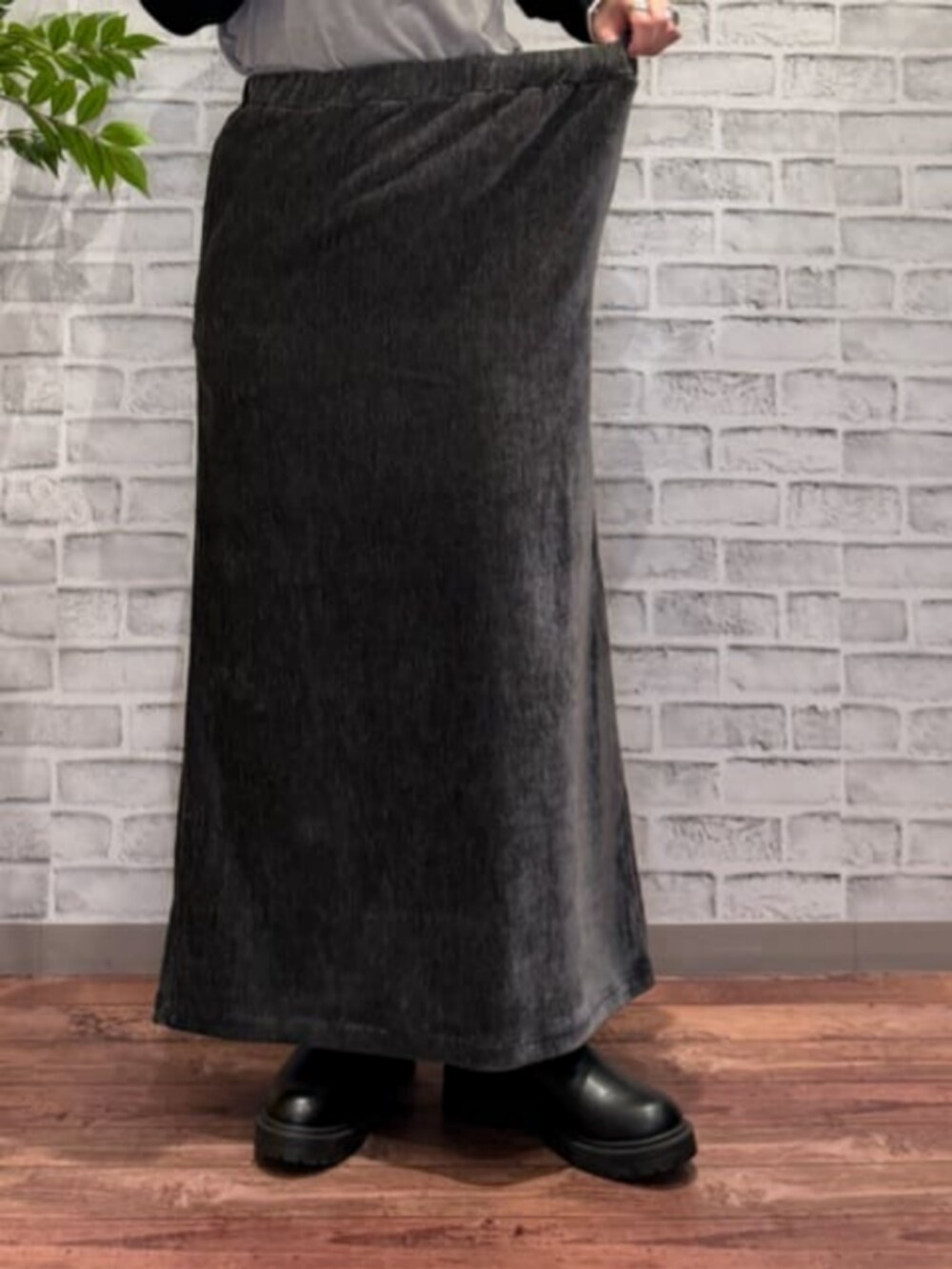 グレー系のスカート、ブラウン系のベスト、ブラック系のニット/セーターを着用したレディースの秋コーディネートの7枚目の写真