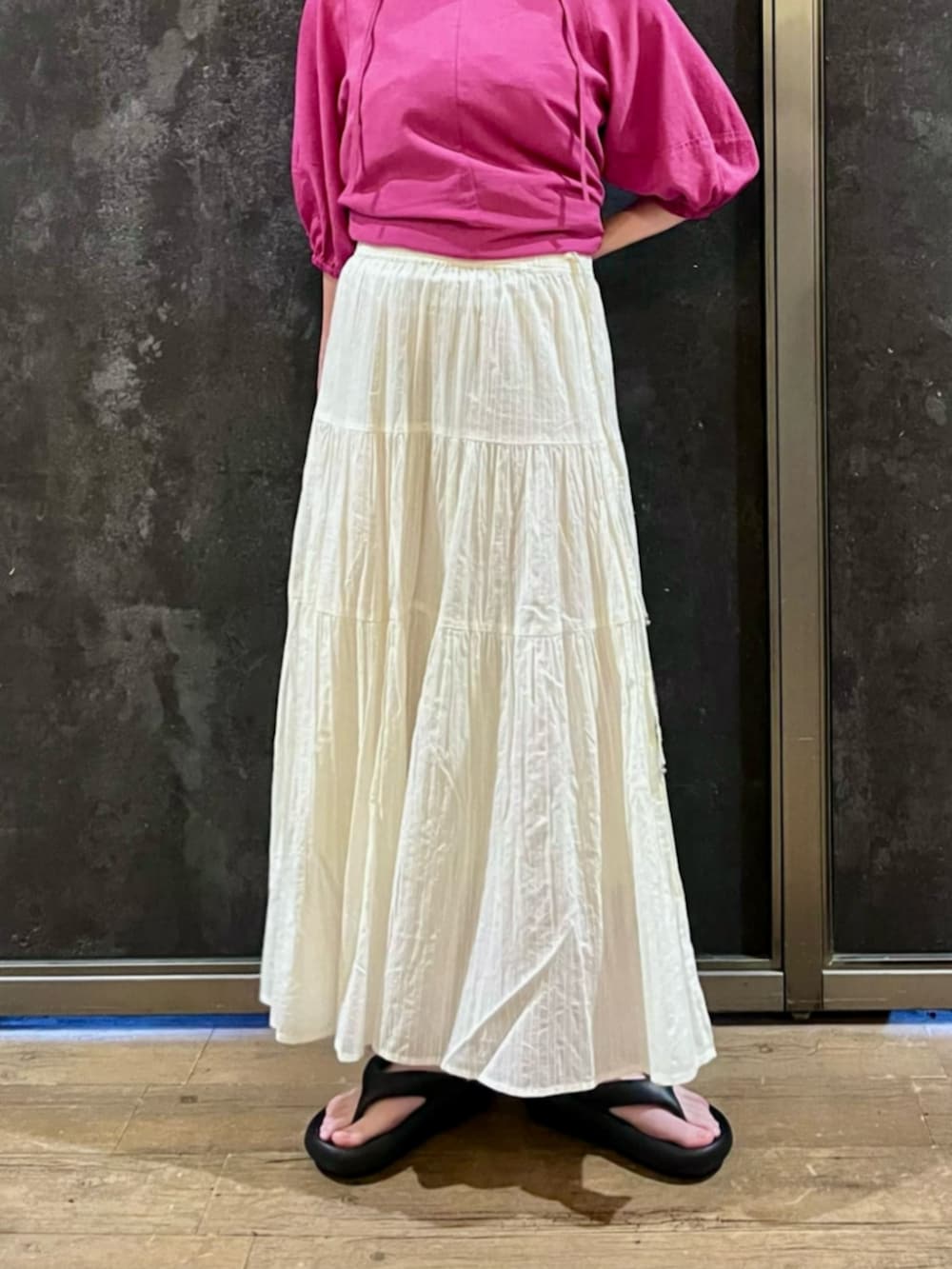 ブラック系のサンダル、ピンク系のシャツワンピース、ホワイト系のスカートを着用したレディースの夏コーディネートの4枚目の写真