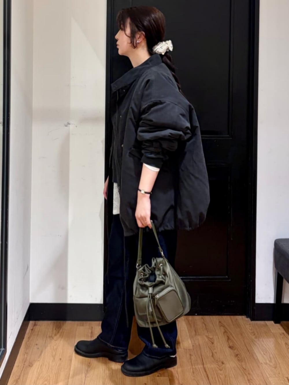 ブラウン系のショルダーバッグ、ブラック系のモッズコート、ブラック系のスウェットを着用したレディースの春コーディネートの2枚目の写真