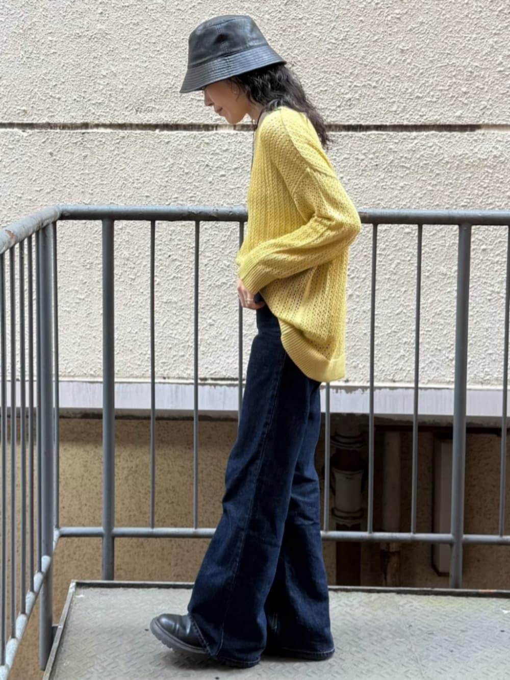 ホワイト系のTシャツ/カットソー、イエロー系のニット/セーター、ブルー系のデニムパンツを着用したレディースの春コーディネートの2枚目の写真