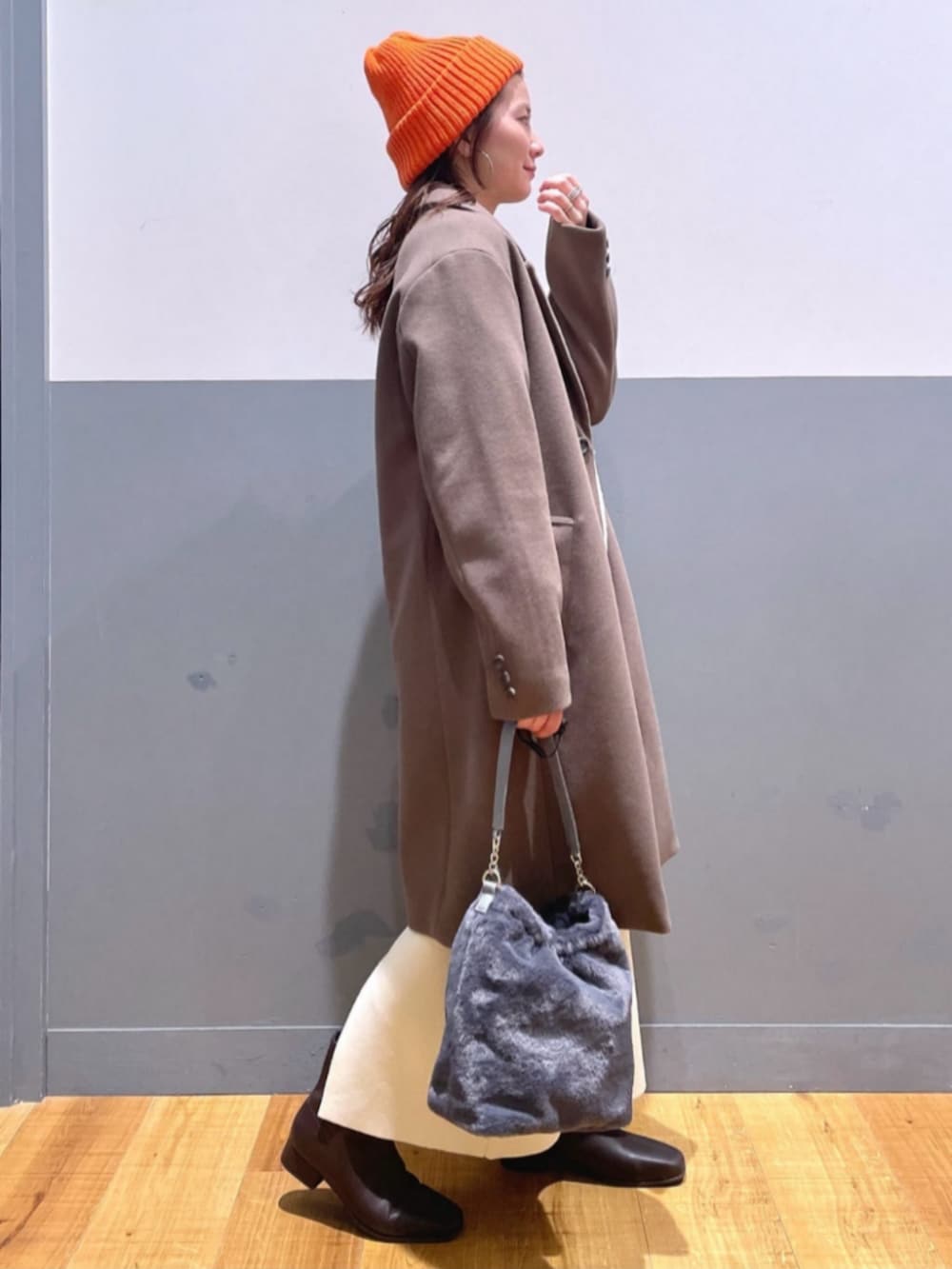 ホワイト系のTシャツ/カットソー、ベージュ系のショルダーバッグ、ブラック系のブーツを着用したレディースの冬コーディネートの2枚目の写真