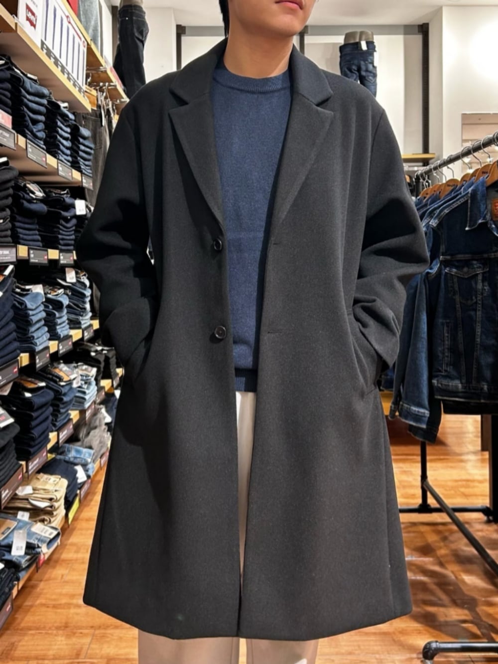 グレー系のその他パンツ、ブルー系のニット/セーター、ブラック系のチェスターコートを着用したメンズの秋コーディネートの5枚目の写真