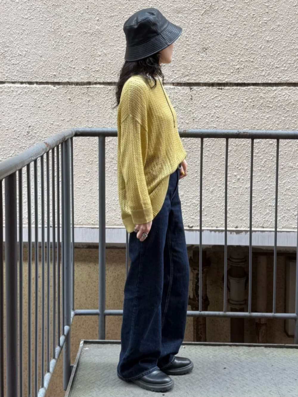 ホワイト系のTシャツ/カットソー、イエロー系のニット/セーター、ブルー系のデニムパンツを着用したレディースの春コーディネートの4枚目の写真