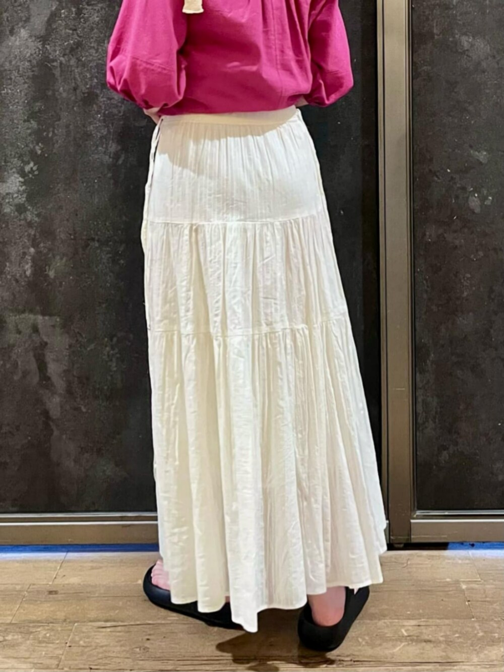 ブラック系のサンダル、ピンク系のシャツワンピース、ホワイト系のスカートを着用したレディースの夏コーディネートの5枚目の写真