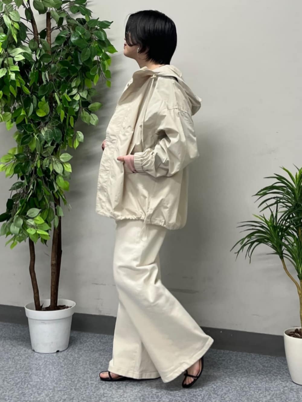 ホワイト系のトートバッグ、ベージュ系のマウンテンパーカー、ホワイト系のデニムパンツを着用したレディースの春コーディネートの2枚目の写真