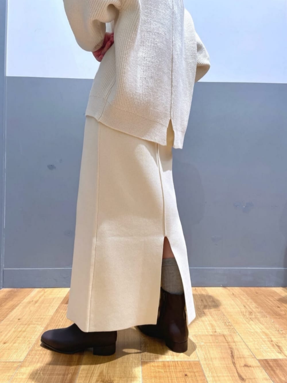 ホワイト系のTシャツ/カットソー、ベージュ系のショルダーバッグ、ブラック系のブーツを着用したレディースの冬コーディネートの9枚目の写真