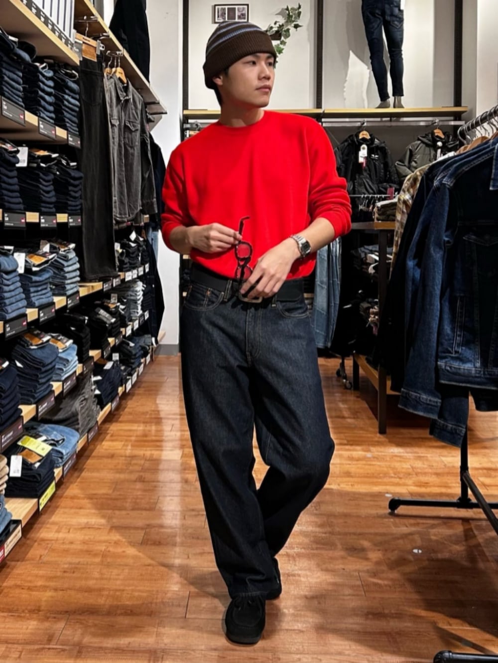 ブルー系のデニムパンツ、レッド系のニット/セーター、ブラウン系のテーラードジャケットを着用したメンズの冬コーディネートの7枚目の写真