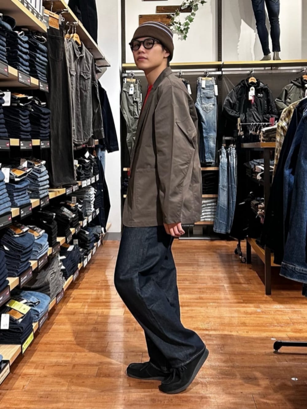 ブルー系のデニムパンツ、レッド系のニット/セーター、ブラウン系のテーラードジャケットを着用したメンズの冬コーディネートの5枚目の写真