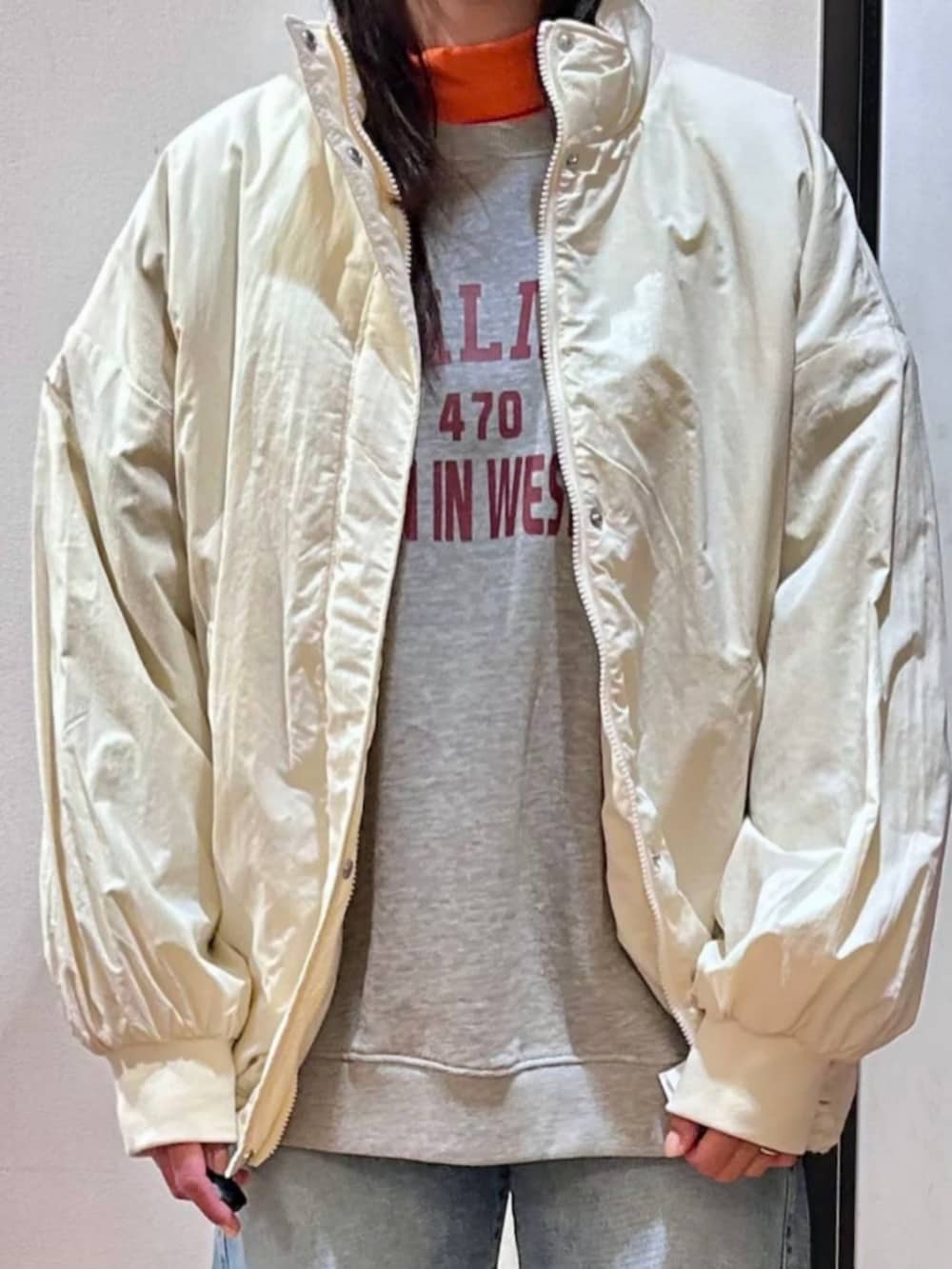 グレー系のスウェット、ブラック系のショルダーバッグ、ブルー系のデニムパンツを着用したレディースの冬コーディネートの6枚目の写真