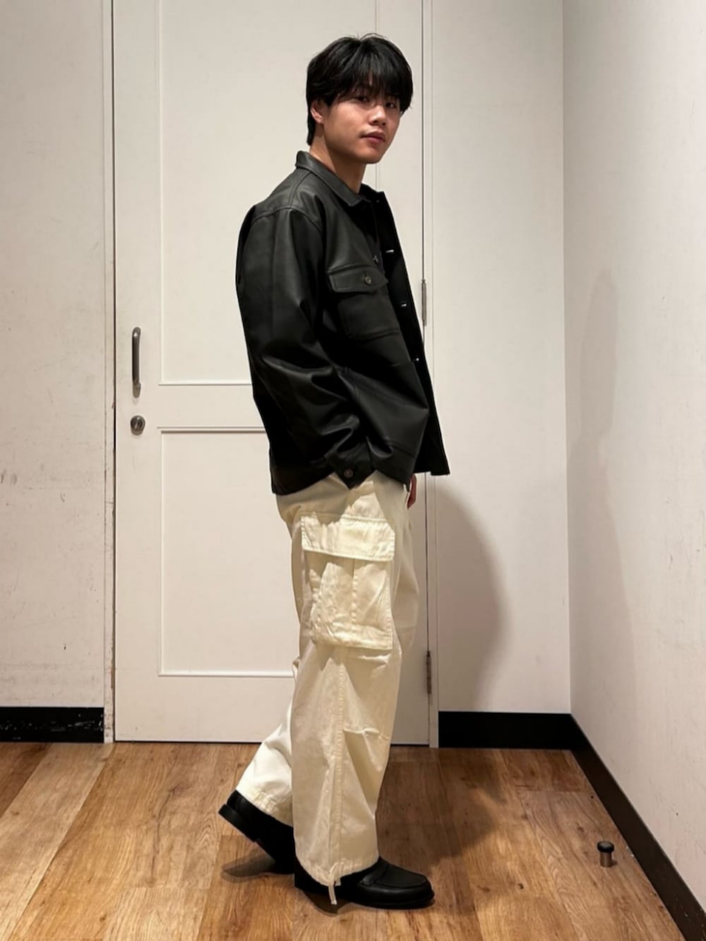 ブラック系のカバーオール、ホワイト系のカーゴパンツ、レッド系のTシャツ/カットソーを着用したメンズの冬コーディネートの4枚目の写真