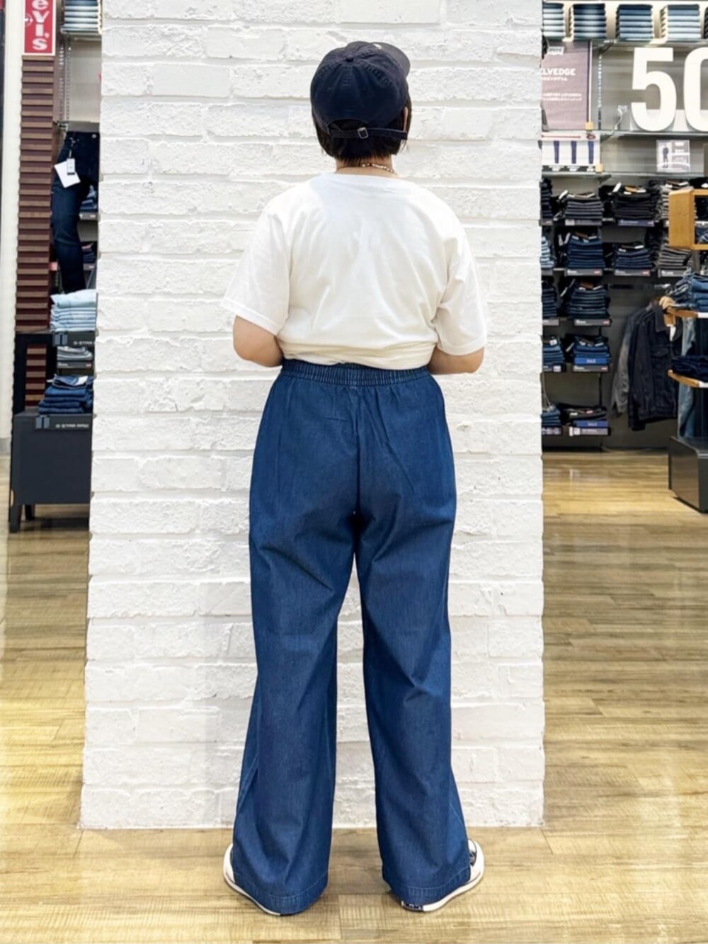 ブルー系のその他パンツ、ブラック系のトートバッグ、ホワイト系のTシャツ/カットソーを着用したレディースの夏コーディネートの9枚目の写真