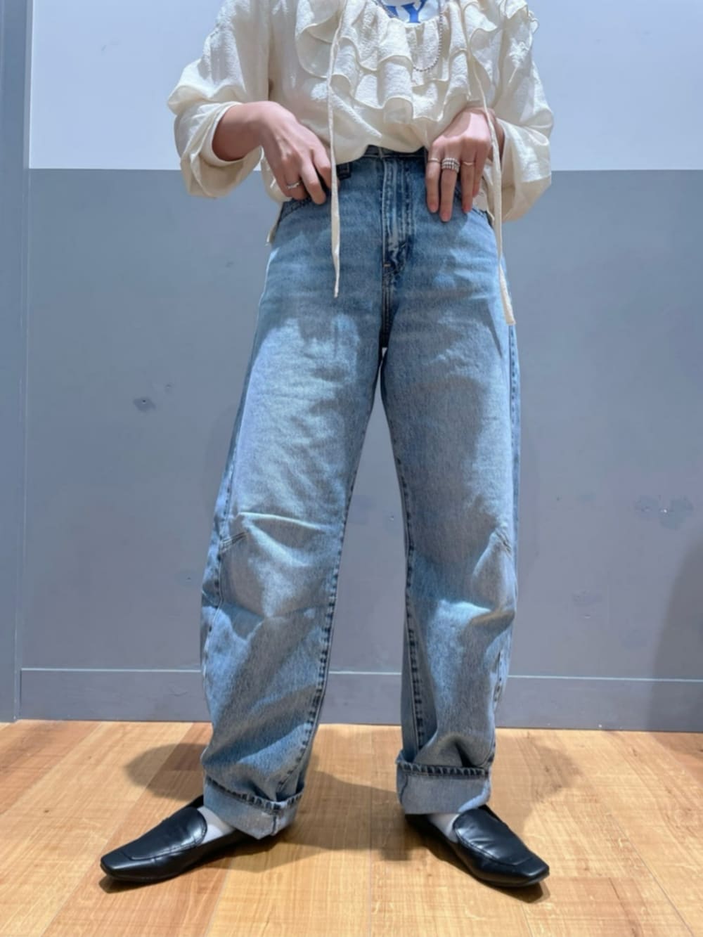 ブラック系のショルダーバッグ、ホワイト系のTシャツ/カットソー、ブルー系のデニムパンツを着用したレディースの秋コーディネートの6枚目の写真