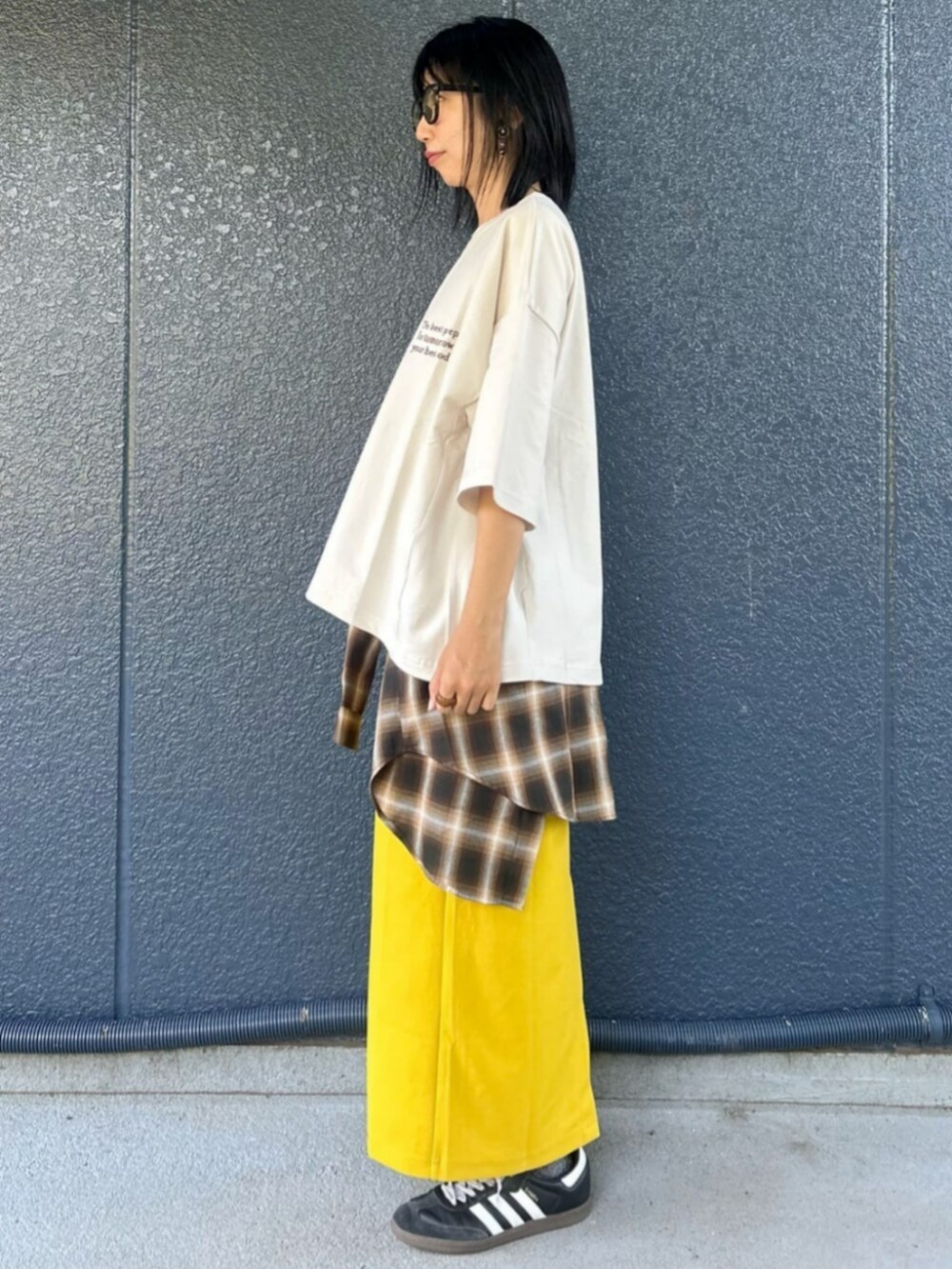 イエロー系のスカート、ホワイト系のTシャツ/カットソー、ブラウン系のシャツ/ブラウスを着用したレディースの秋コーディネートの3枚目の写真
