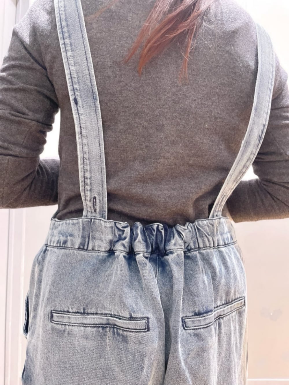 グレー系のパーカー、ブルー系のサロペット/オーバーオール、レッド系のキャップを着用したレディースの春コーディネートの9枚目の写真