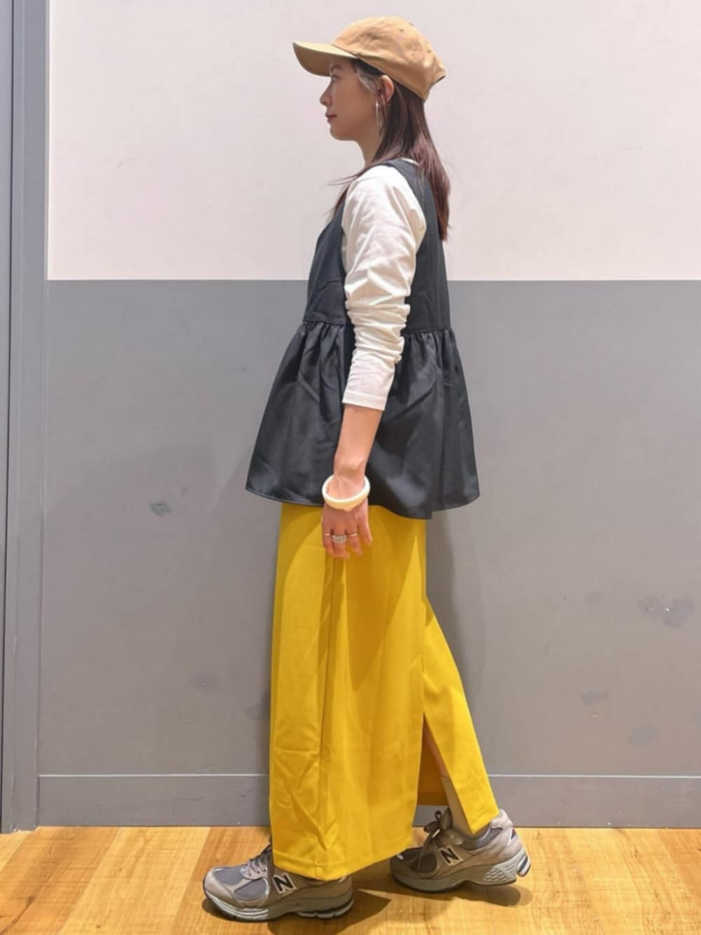 イエロー系のスカート、ホワイト系のTシャツ/カットソー、グレー系のその他トップスを着用したレディースの秋コーディネートの4枚目の写真