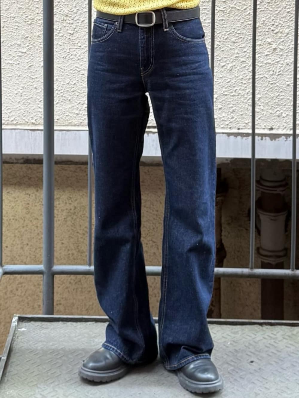 ホワイト系のTシャツ/カットソー、イエロー系のニット/セーター、ブルー系のデニムパンツを着用したレディースの春コーディネートの5枚目の写真