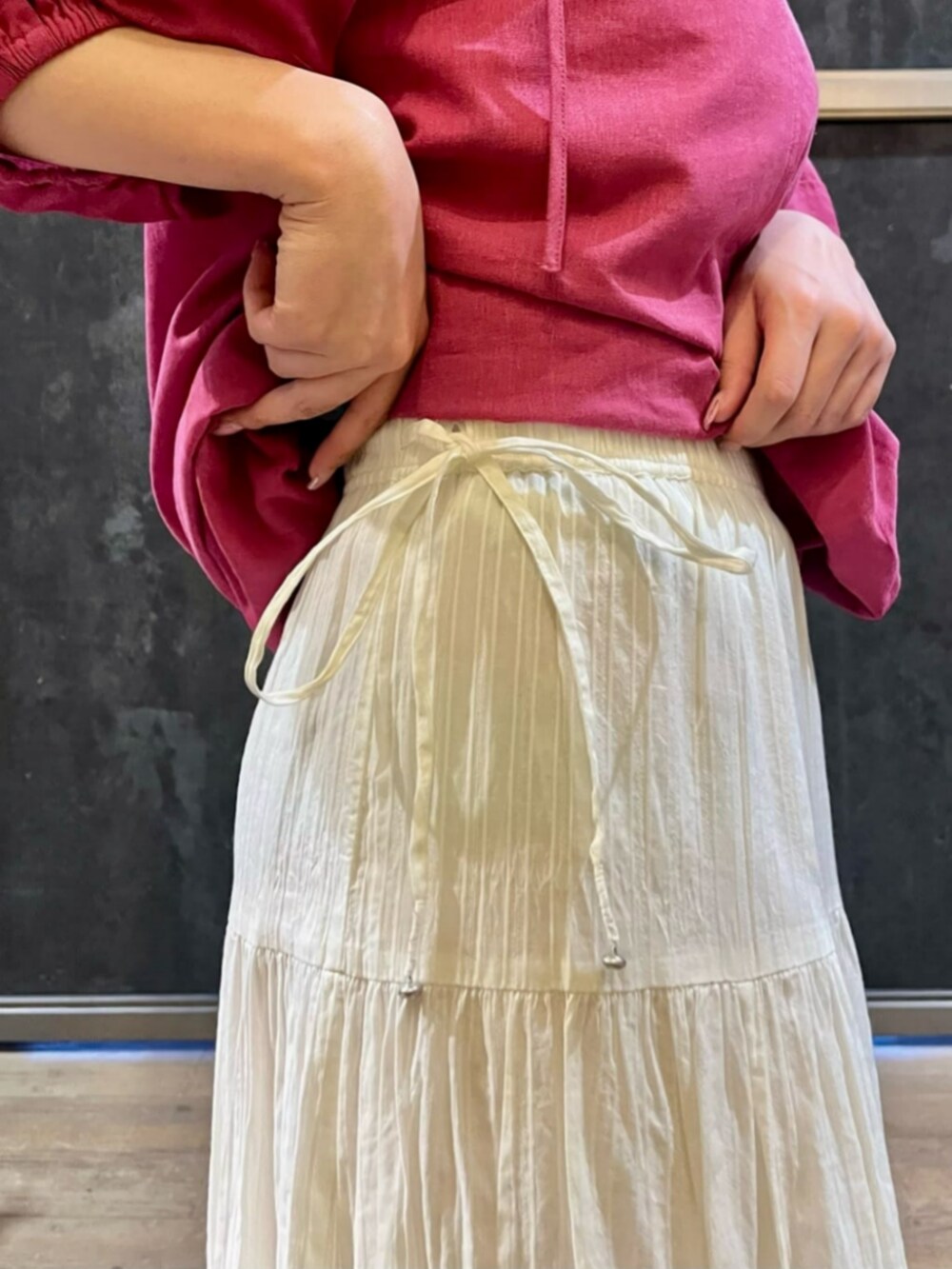 ブラック系のサンダル、ピンク系のシャツワンピース、ホワイト系のスカートを着用したレディースの夏コーディネートの6枚目の写真