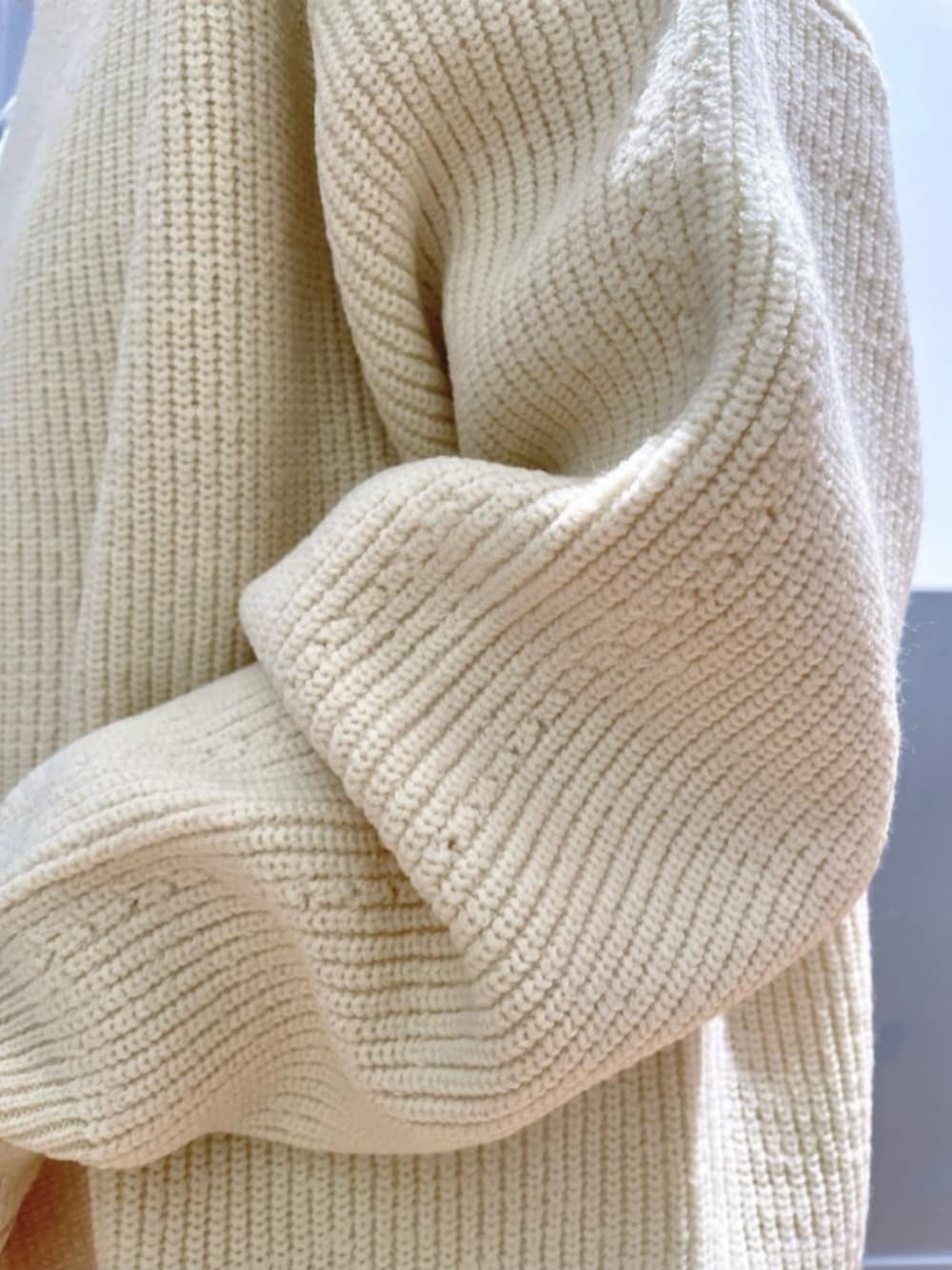 ホワイト系のTシャツ/カットソー、ベージュ系のショルダーバッグ、ブラック系のブーツを着用したレディースの冬コーディネートの7枚目の写真