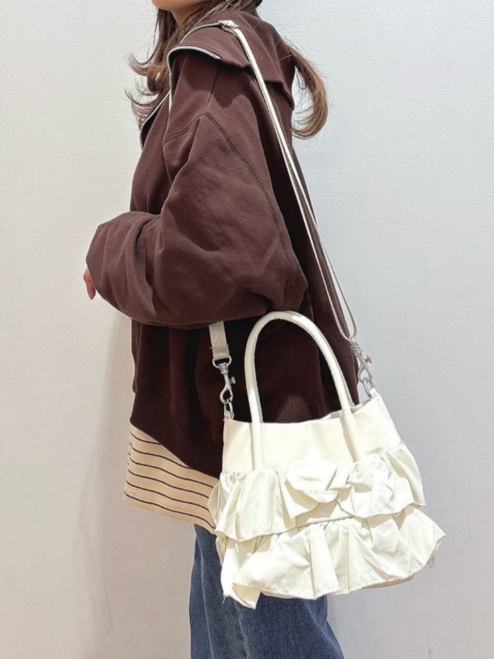 ピンク系のスウェット、ブルー系のその他トップス、ブルー系のデニムパンツを着用したレディースの冬コーディネートの9枚目の写真