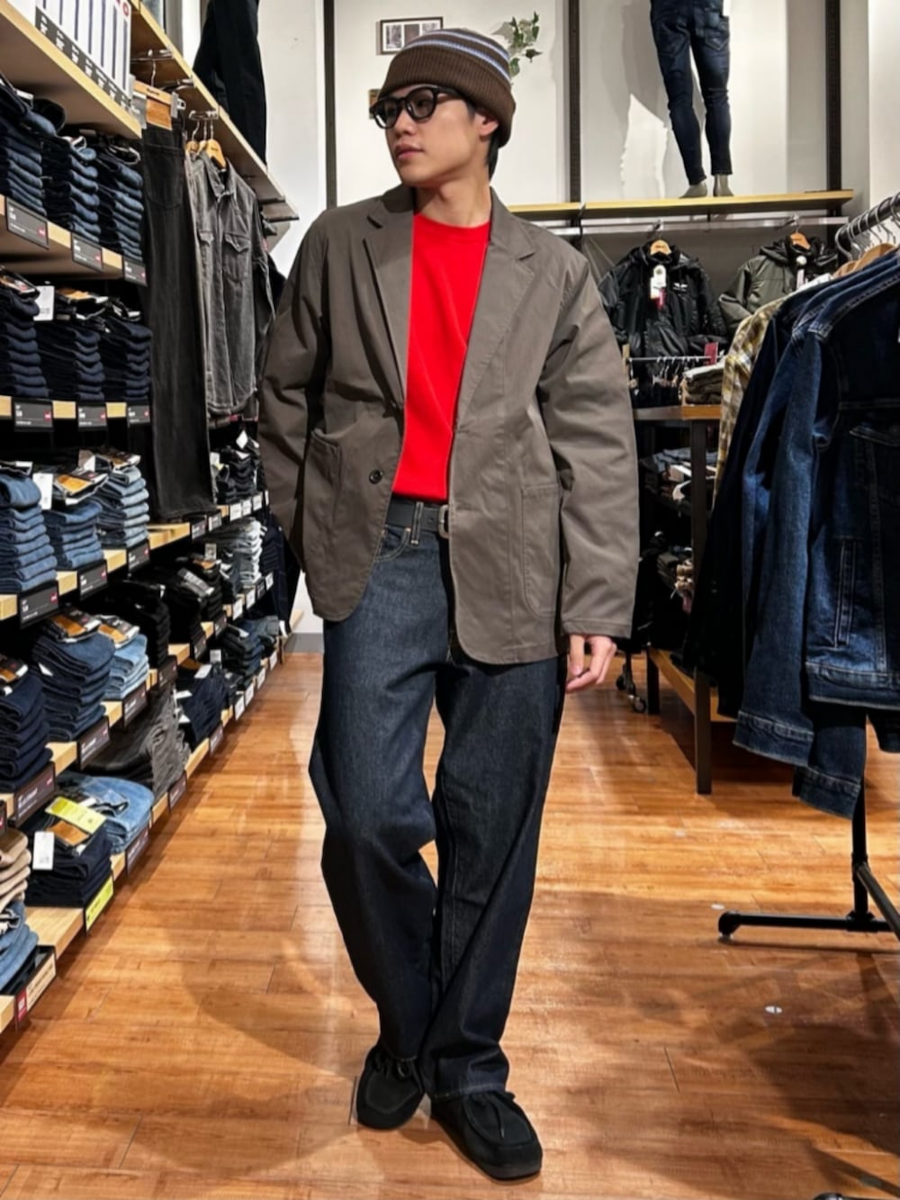 ブルー系のデニムパンツ、レッド系のニット/セーター、ブラウン系のテーラードジャケットを着用したメンズの冬コーディネートの2枚目の写真