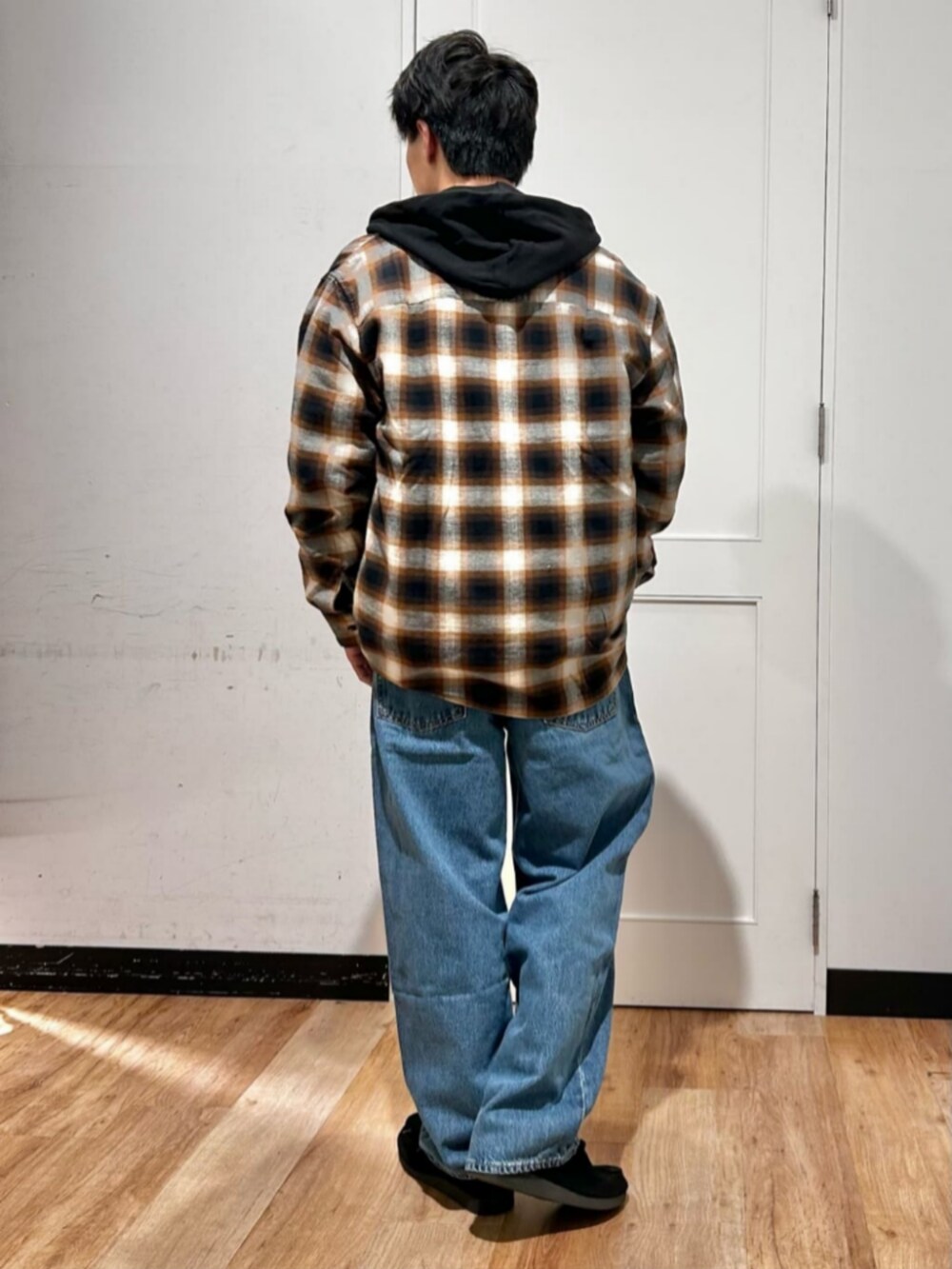 ホワイト系のTシャツ/カットソー、ブラック系のパーカー、ブルー系のデニムパンツを着用したメンズの冬コーディネートの3枚目の写真