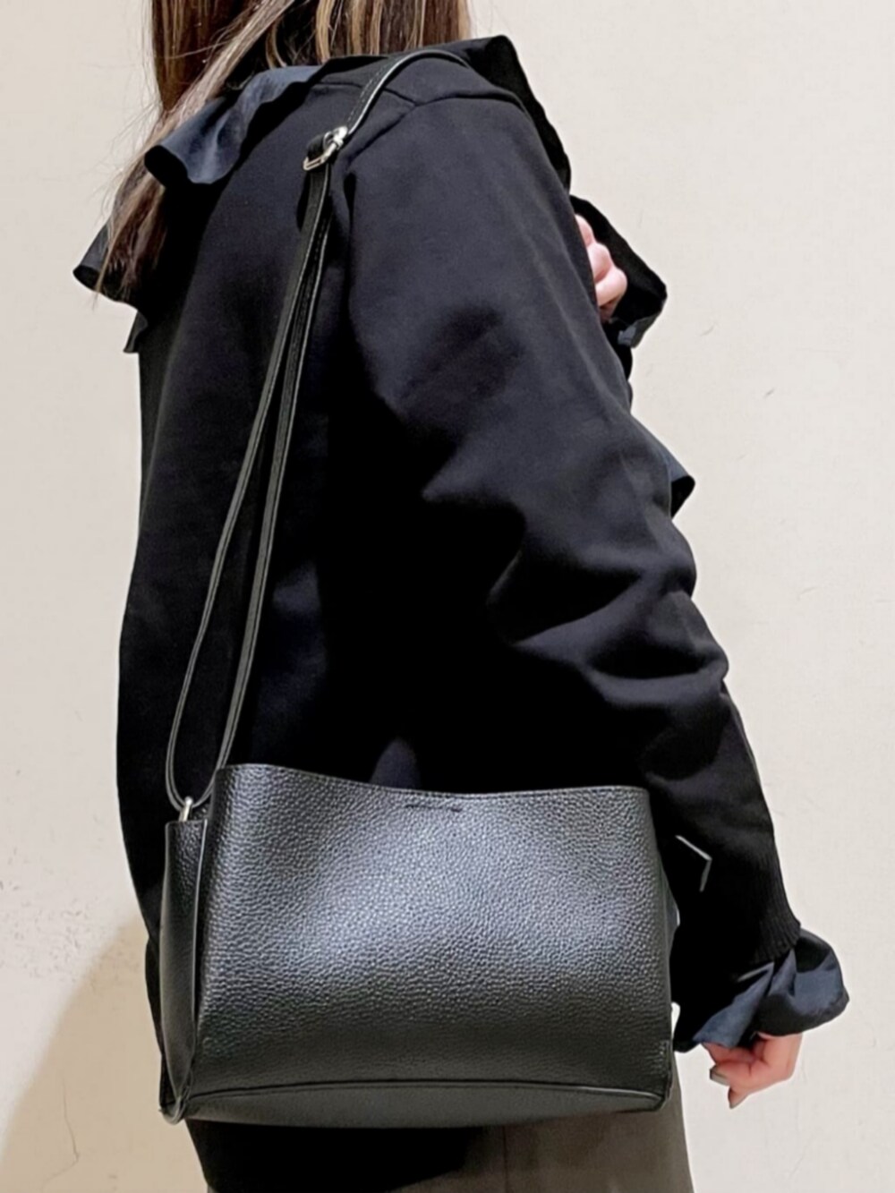 ブラック系のショルダーバッグ、ブラック系のブーツ、ブラック系のシャツ/ブラウスを着用したレディースの冬コーディネートの3枚目の写真