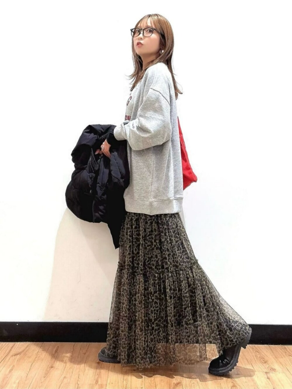 グレー系のスウェット、ブラウン系のスカート、ブラック系のTシャツ/カットソーを着用したレディースの秋コーディネートの5枚目の写真