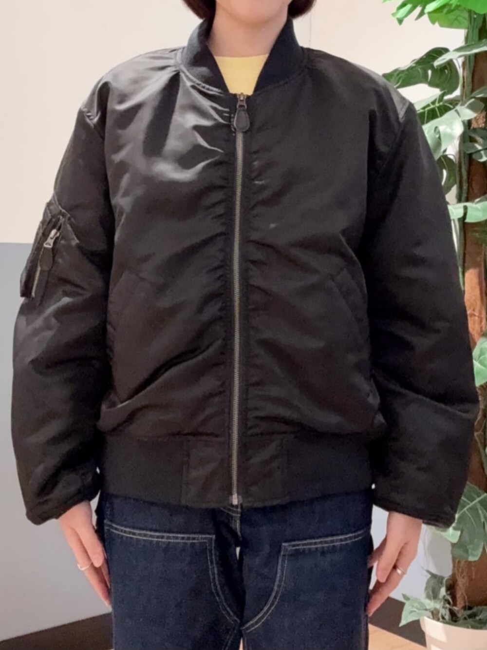 ブラック系のMA-1、イエロー系のスウェット、ブルー系のデニムパンツを着用したレディースの冬コーディネートの6枚目の写真